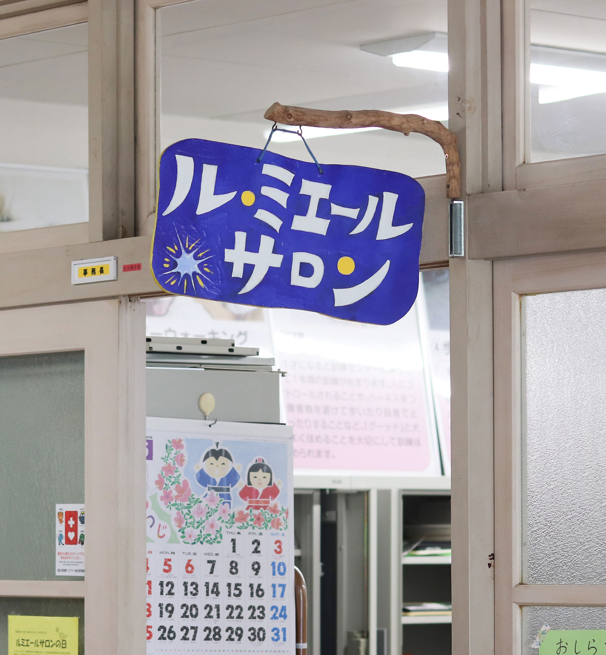 写真：手作りの「ルミエールサロン」看板