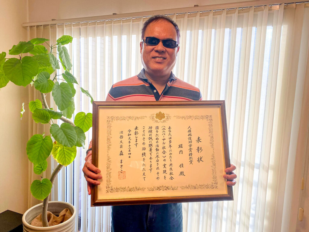 写真：表彰状を持った堀内さん